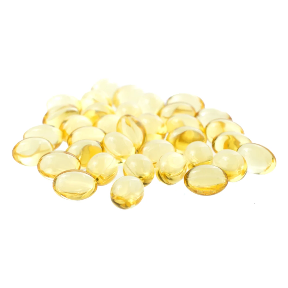 Golden Vitamin E capsules on a white background