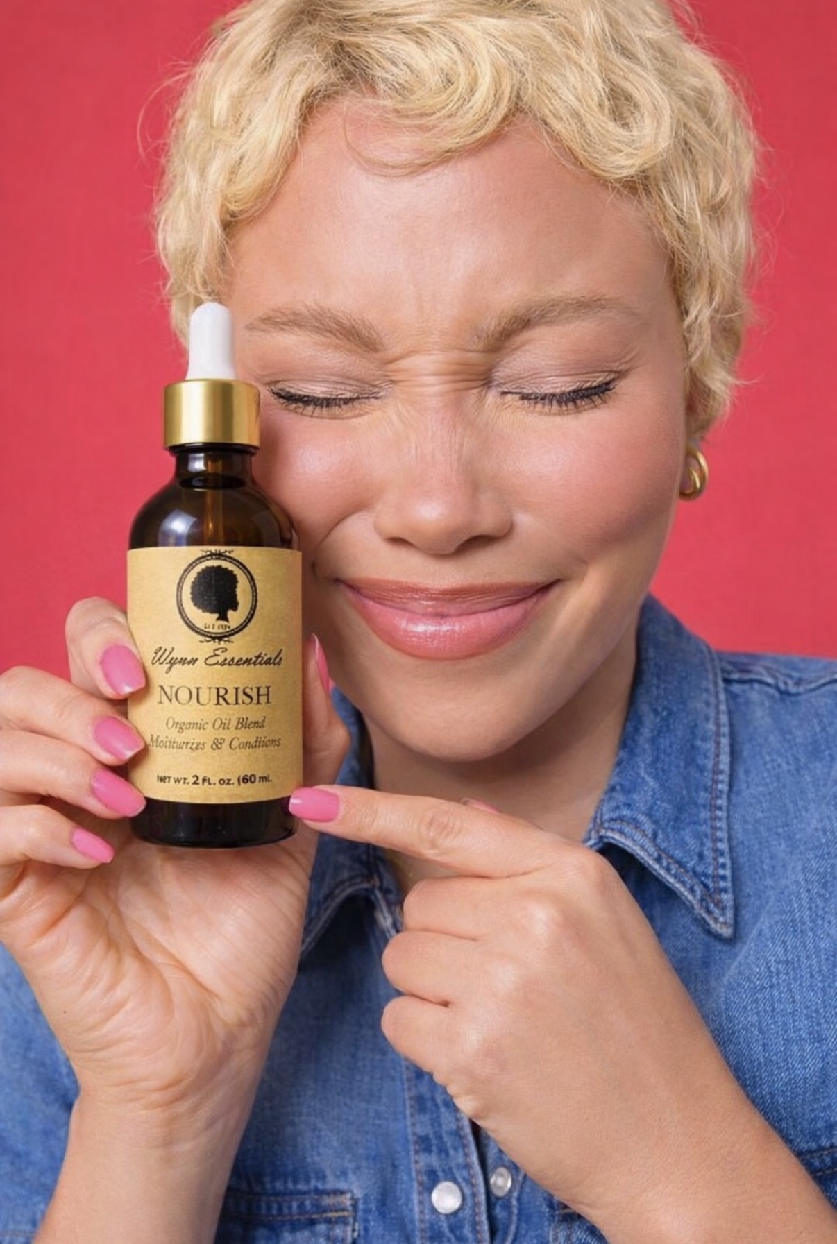 Model smiling while holding Nourish Oil