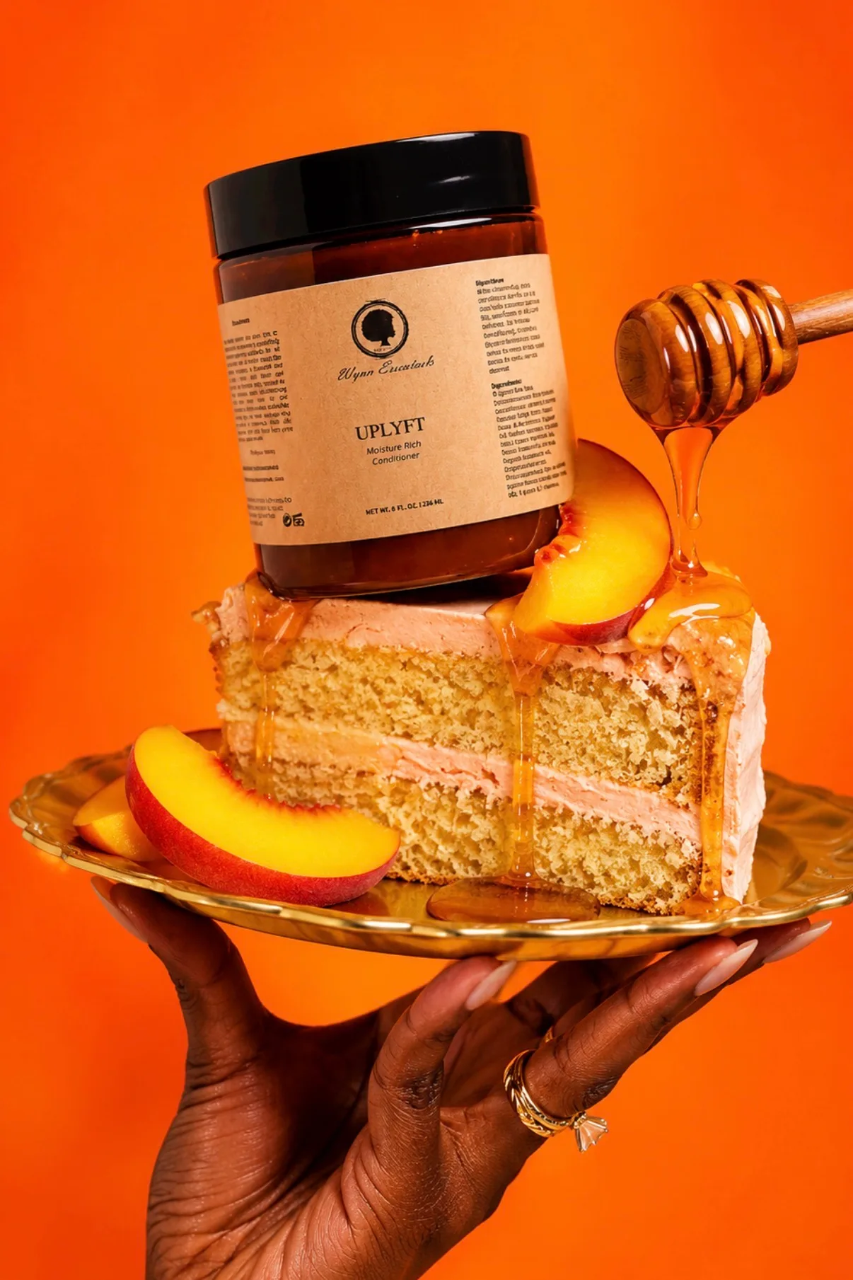 Hand holding a gold plate of peach cake and honey topped with a jar of Uplyft Moisture Rich Conditioner